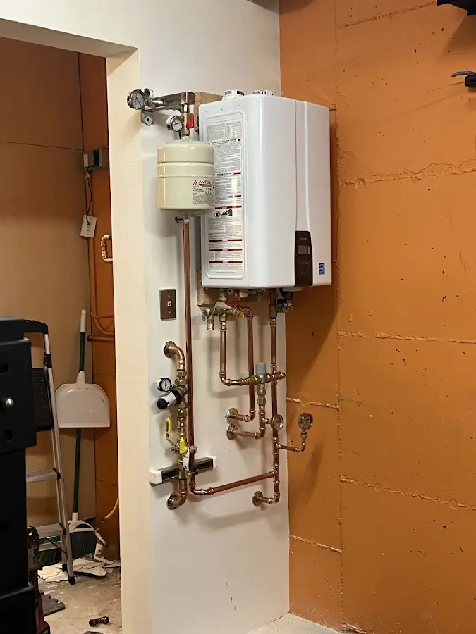 Plumbing technician inspecting water heater connections in Gulf Hills